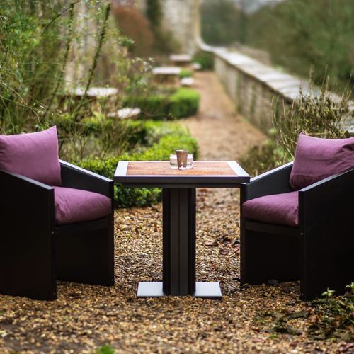 Ironfire Bistro Table with rust top and purple cushioned chairs